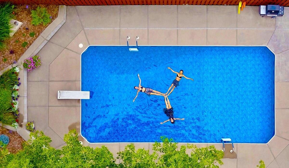 Aerial view of people floating in an in-ground pool