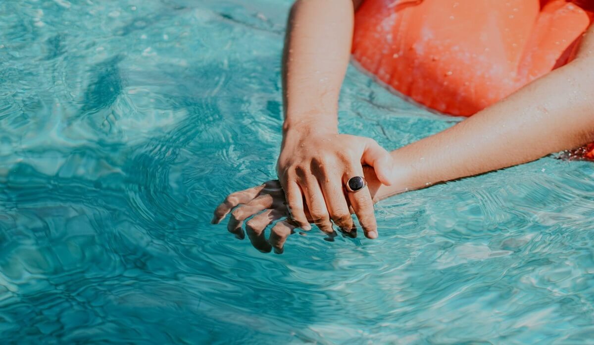 Arms of a person floating in a swimming pool