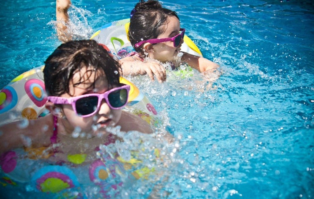 Two little girls swimming in a clean pool