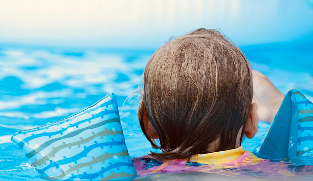 Young child swimming in a backyard pool
